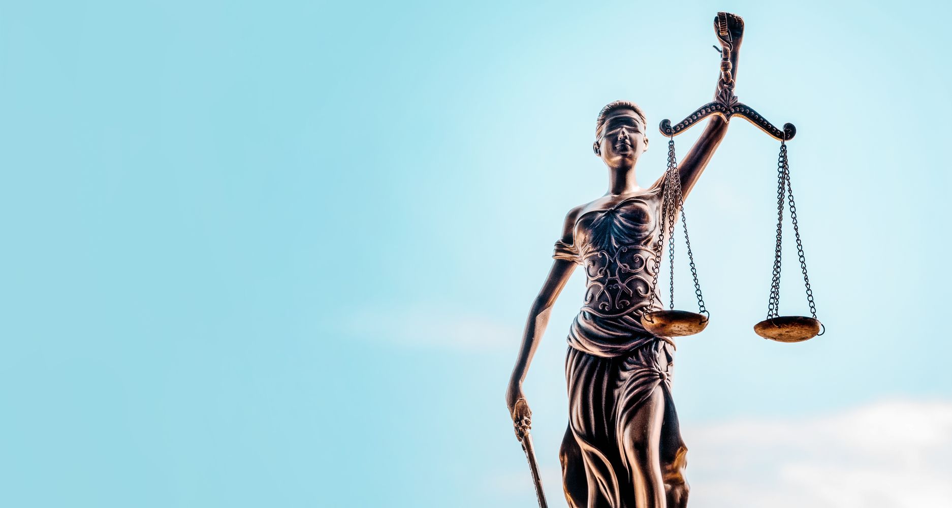Statue der Gerechtigkeit, die eine Waage hält, symbolisiert das Streben nach Fairness und Gleichgewicht in der Rechtsprechung.